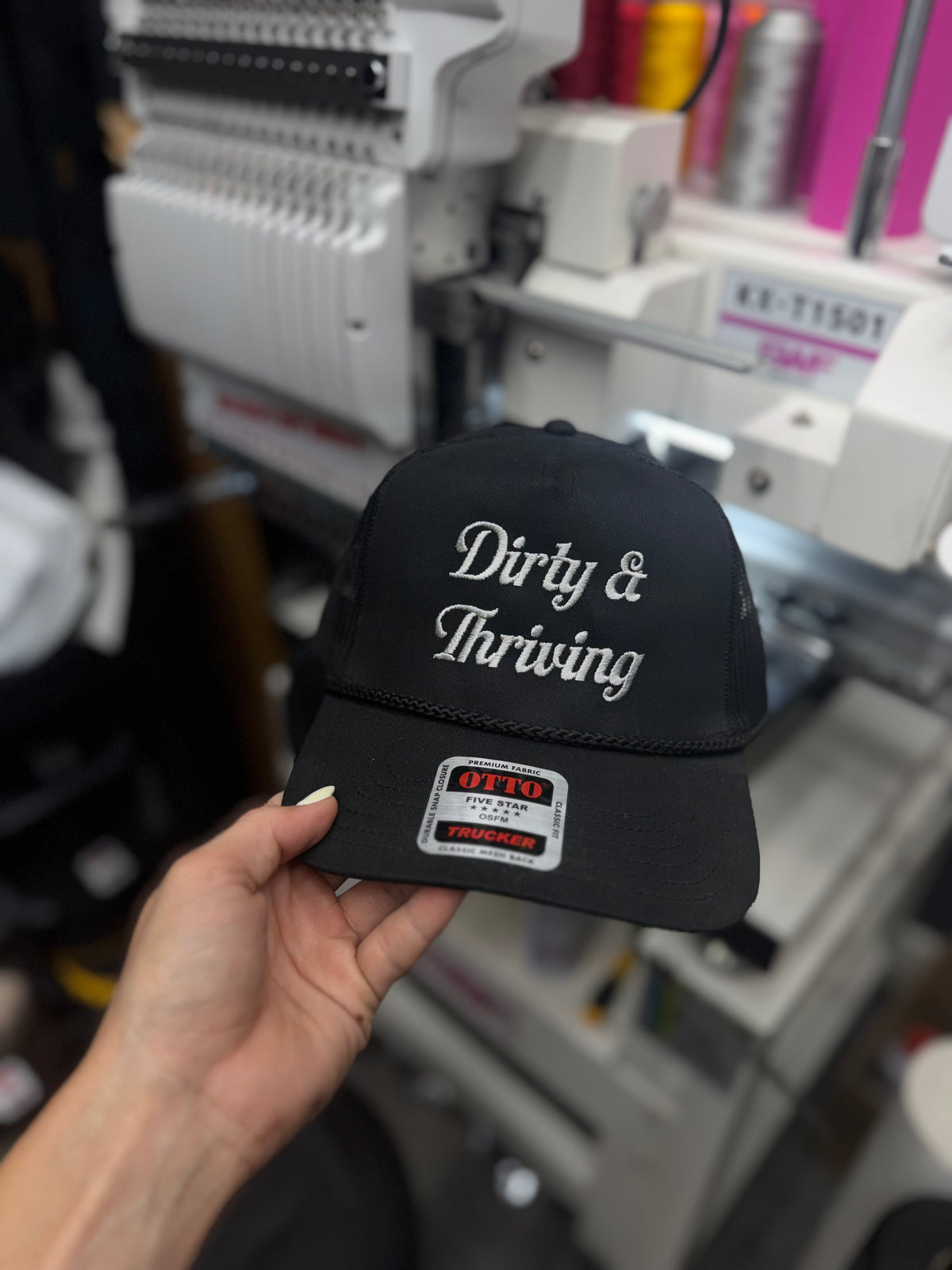 a hand holding a black hat