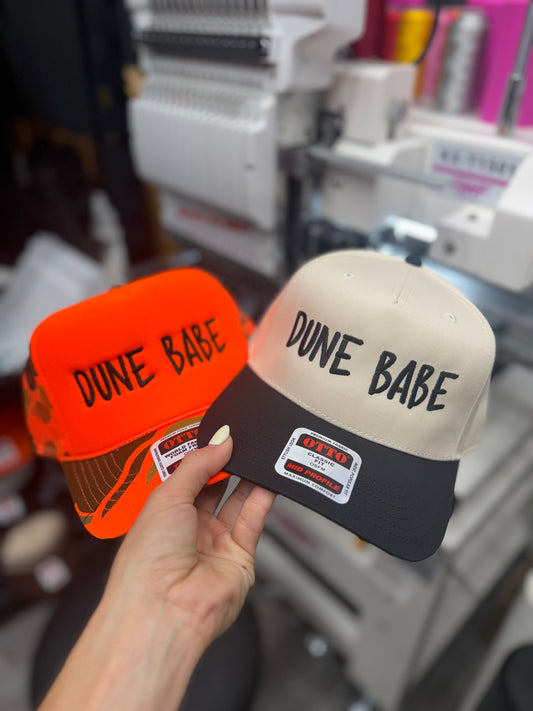 a hand holding a pair of hats