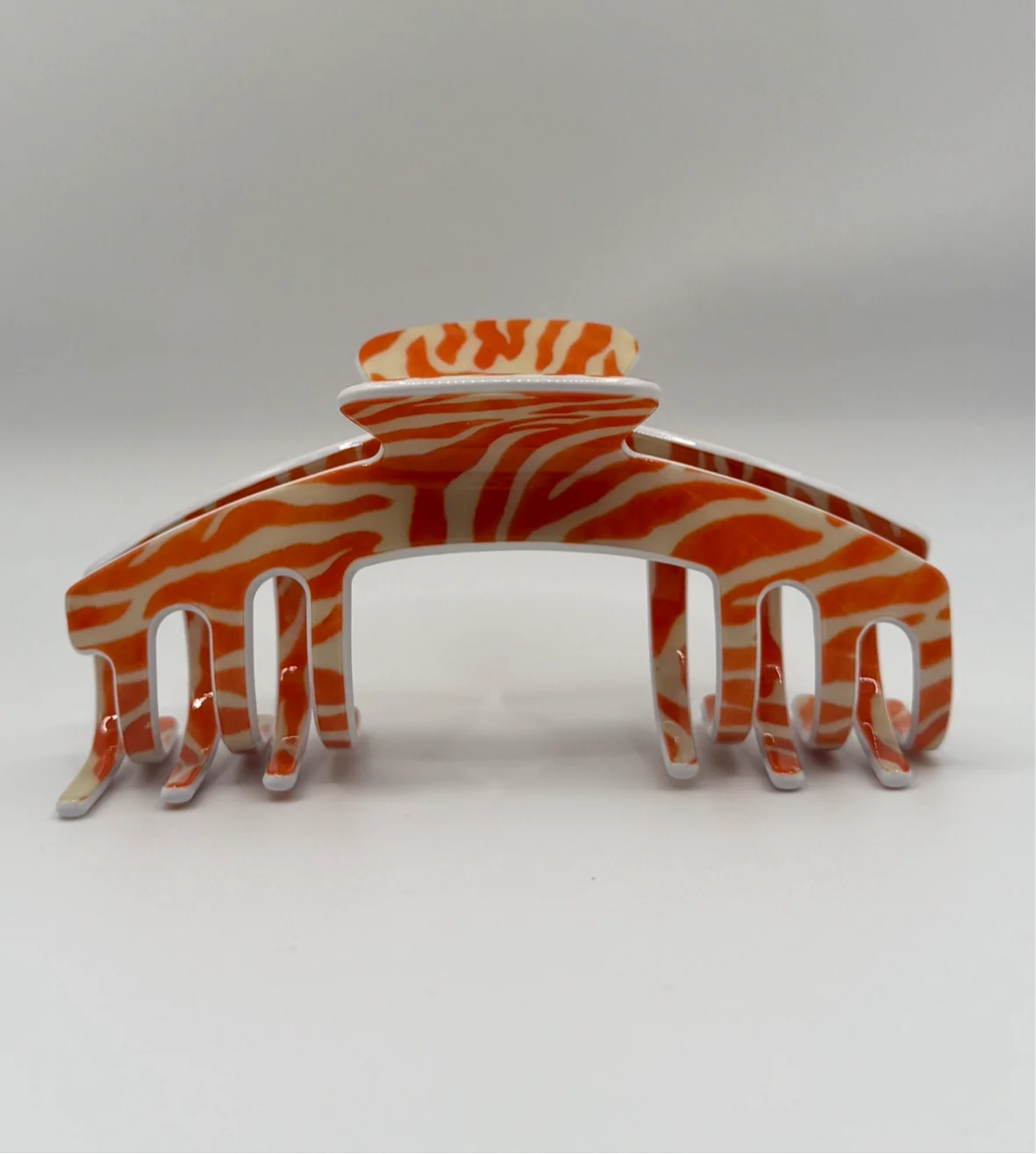 a hair clip with orange and white stripes